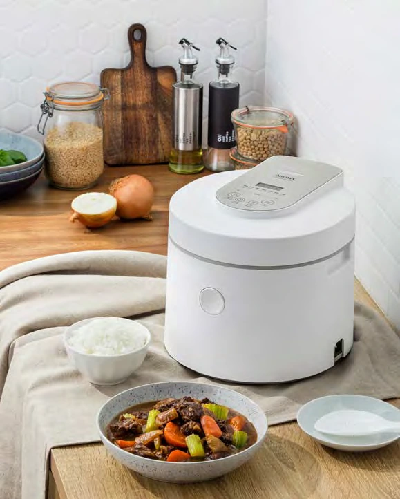 Aroma ARC-7206P purple-clay rice and grain multicooker on a kitchen counter beside rice and stew; manufacturer catalog image, photo-versus-render status unknown.